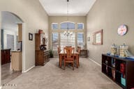 818 E Hiddenview Dr, Phoenix, AZ 85048 - dining room with a chandelier, arched walkways, baseboards, and light colored carpet