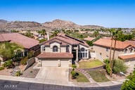 818 E Hiddenview Dr, Phoenix, AZ 85048 - split level home featuring concrete driveway, a garage, and a mountain view