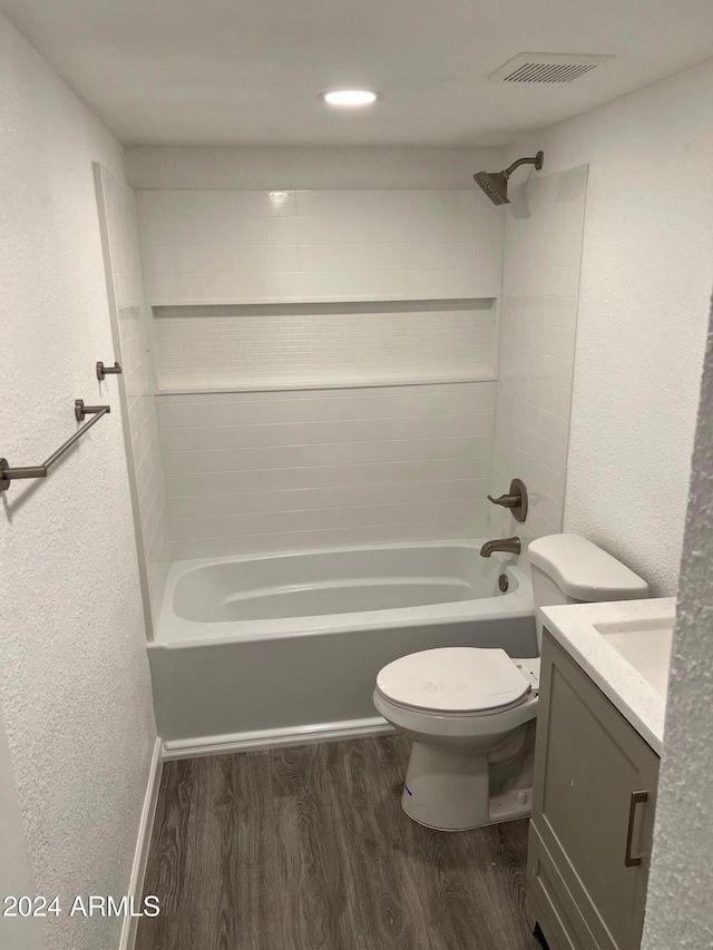 full bathroom featuring toilet, hardwood / wood-style floors, vanity, and tiled shower / bath