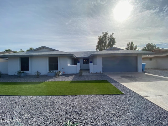 ranch-style home featuring a garage, concrete driveway, and stucco siding