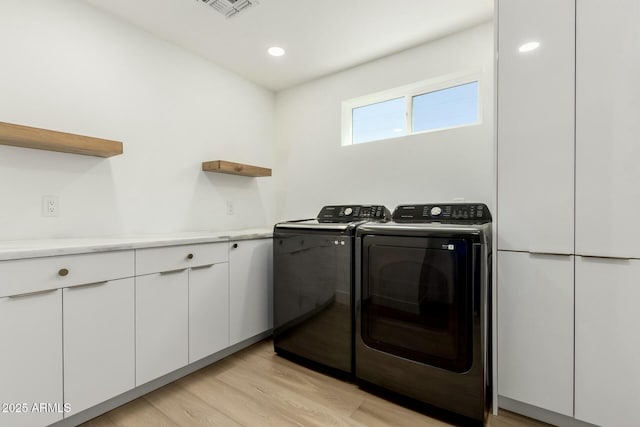 laundry room with visible vents, recessed lighting, washer and dryer, and light wood-style floors