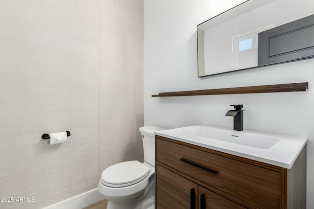 half bathroom featuring vanity and toilet