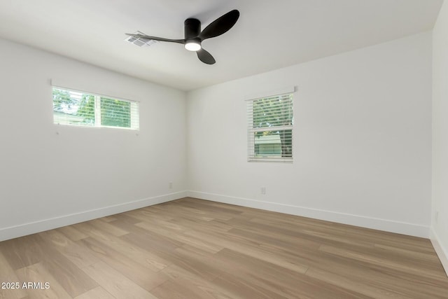 empty room with light wood-style flooring, baseboards, visible vents, and ceiling fan