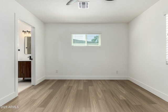 unfurnished room featuring visible vents, baseboards, and light wood-style flooring