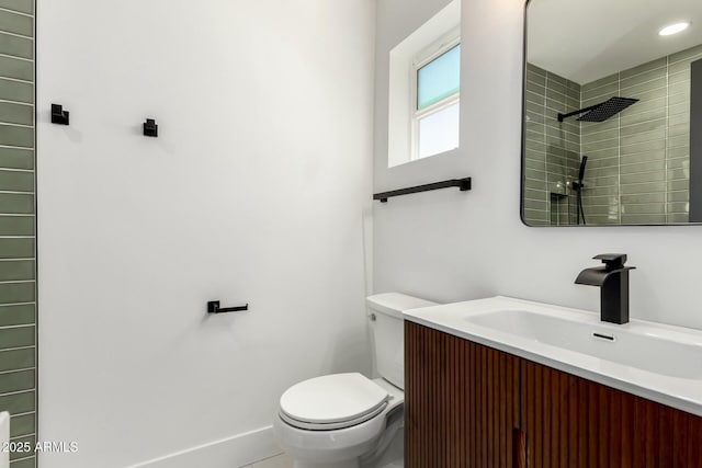 bathroom with toilet, vanity, and a tile shower