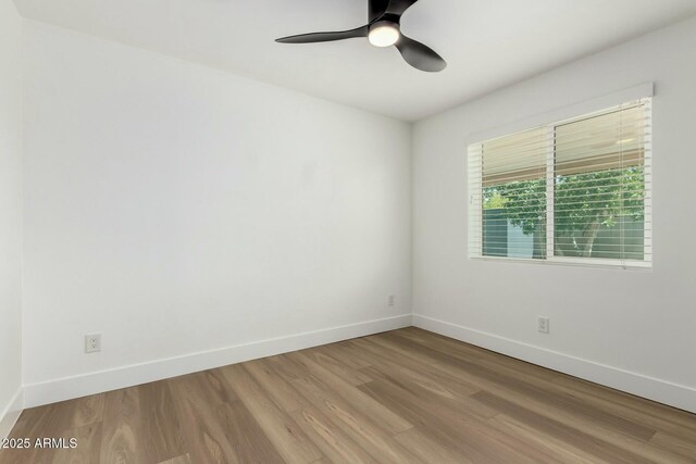 empty room with baseboards, ceiling fan, and wood finished floors