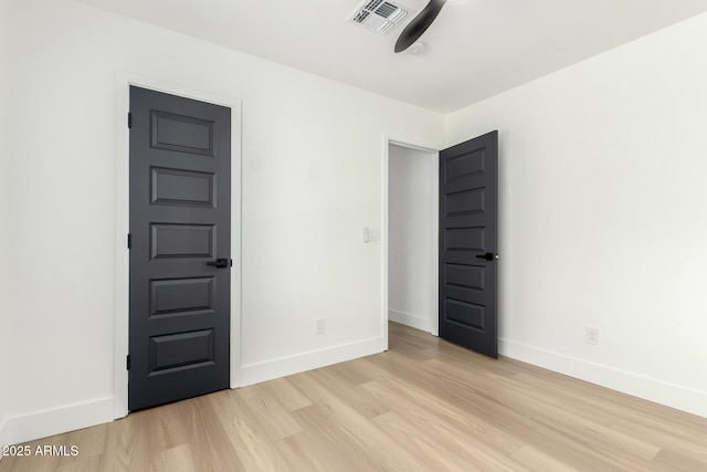 unfurnished bedroom with light wood finished floors, visible vents, and baseboards