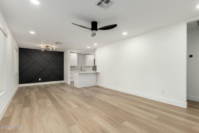 unfurnished living room featuring light wood-style floors, recessed lighting, visible vents, and baseboards