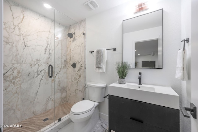 bathroom with vanity, toilet, and a shower with door