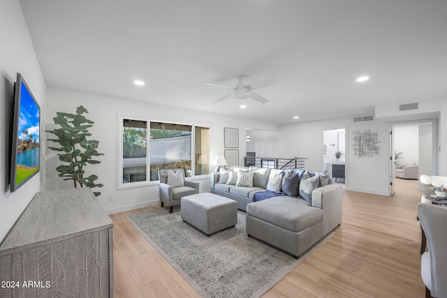 living room with light wood-type flooring and ceiling fan