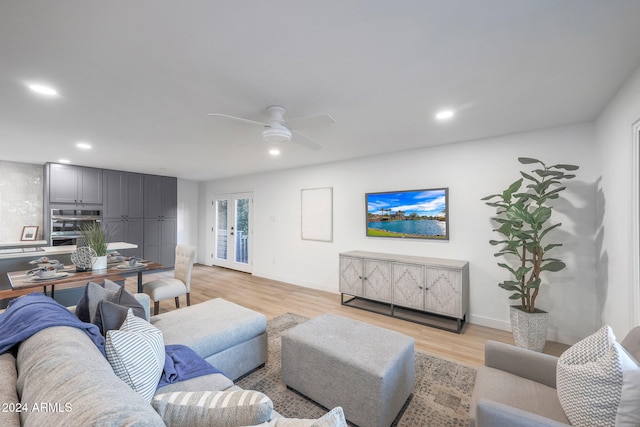 living room with ceiling fan and light hardwood / wood-style flooring