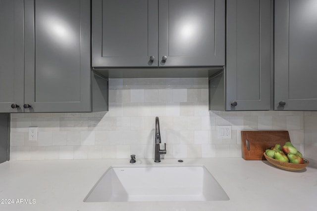 kitchen with gray cabinets, sink, and backsplash