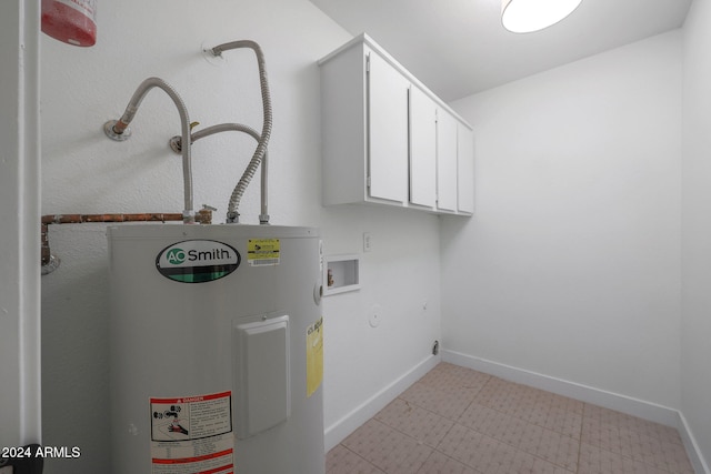 clothes washing area with electric water heater, washer hookup, and cabinets