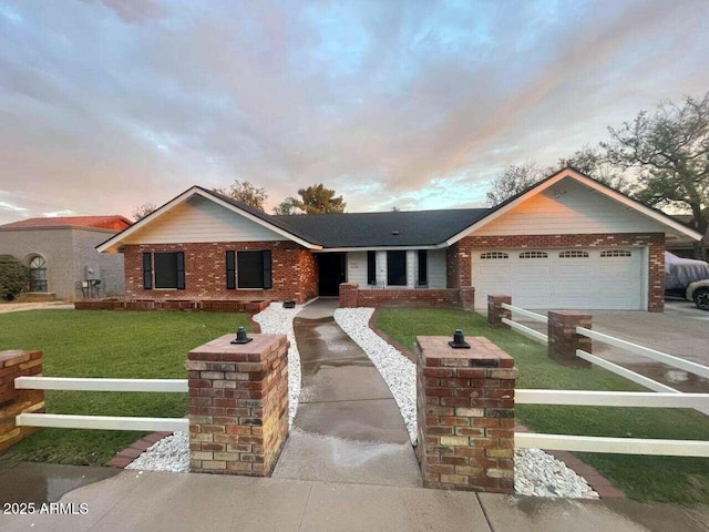 single story home featuring driveway, a garage, fence, a front lawn, and brick siding