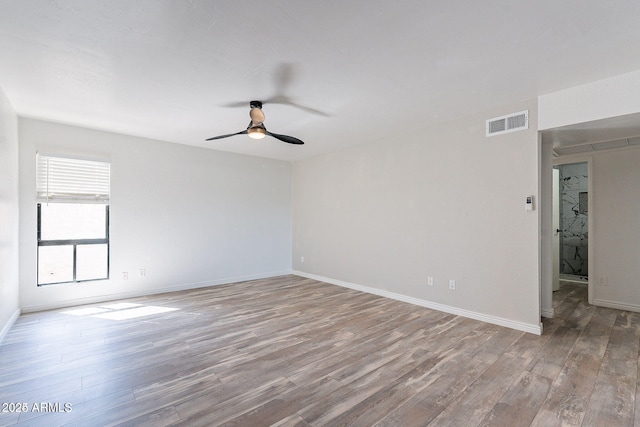 unfurnished room featuring wood finished floors, ceiling fan, and baseboards
