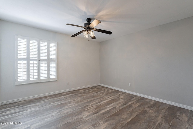 empty room with dark wood-style flooring, baseboards, and a ceiling fan