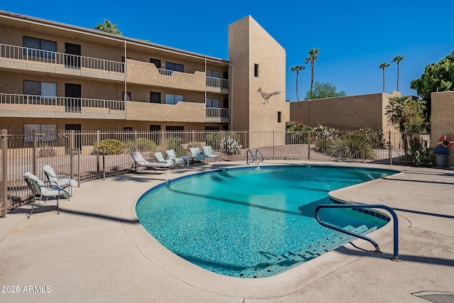 community pool featuring fence and a patio