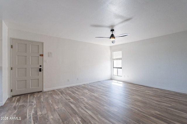 unfurnished room with ceiling fan, wood finished floors, and baseboards