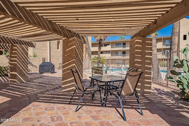 view of patio with a pergola, fence, a community pool, and outdoor dining area