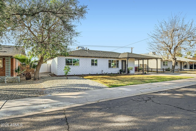 view of front facade featuring a front yard, fence, and brick siding