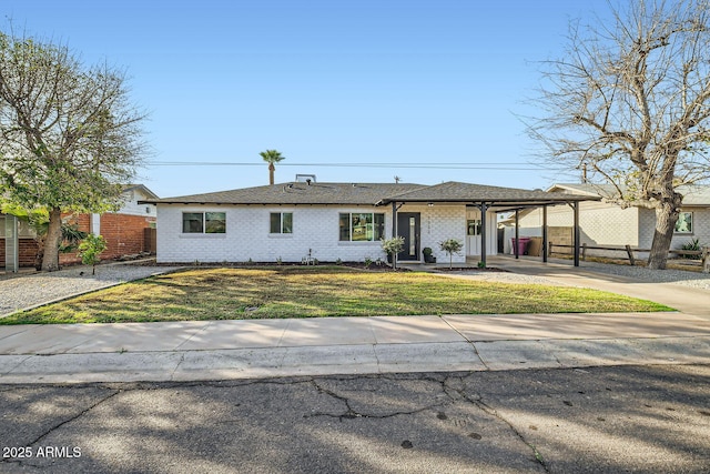 view of front of house featuring an attached carport, brick siding, fence, driveway, and a front lawn