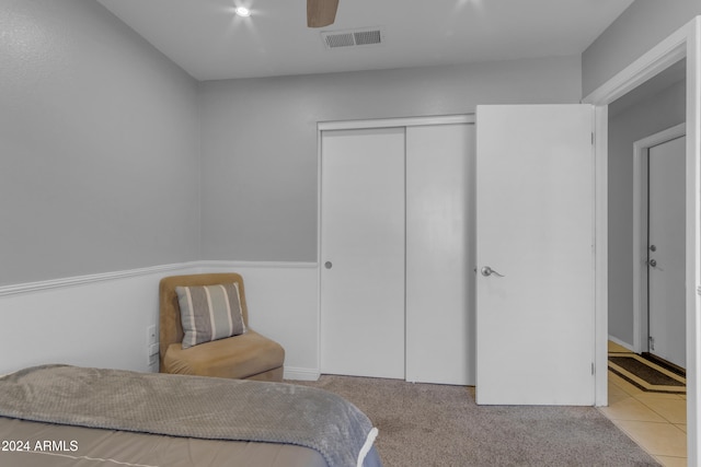 carpeted bedroom featuring ceiling fan and a closet