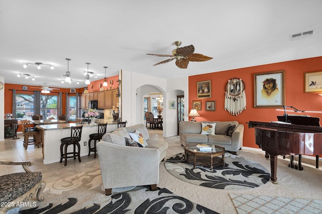 living room with ceiling fan and light tile patterned flooring