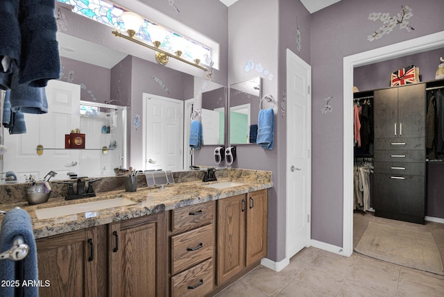 bathroom with a shower with shower door, tile patterned floors, and vanity