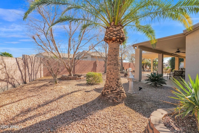 view of yard featuring ceiling fan and a patio