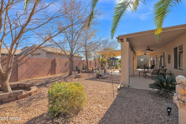 view of yard with ceiling fan and a patio area