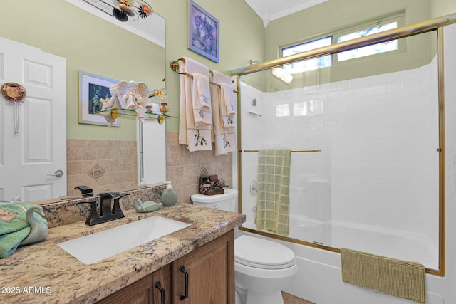 full bathroom with combined bath / shower with glass door, vanity, backsplash, and toilet