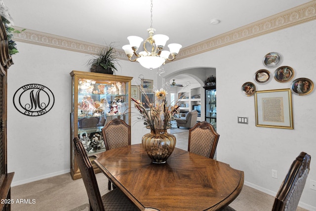 dining area featuring light colored carpet, an inviting chandelier, and ornamental molding