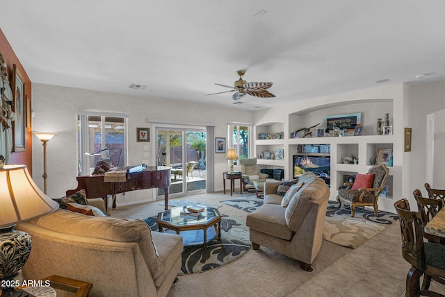 living room featuring ceiling fan and built in shelves