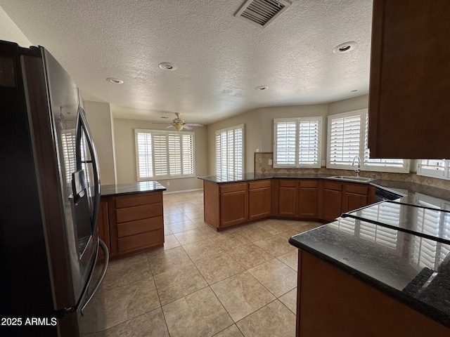 2077 N Lake Shore Dr, Casa Grande, AZ 85122 - kitchen with freestanding refrigerator, a peninsula, a sink, and visible vents