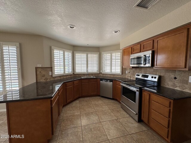 2077 N Lake Shore Dr, Casa Grande, AZ 85122 - kitchen featuring visible vents, a peninsula, backsplash, and stainless steel appliances