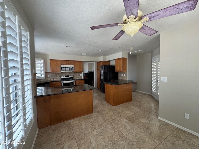 2077 N Lake Shore Dr, Casa Grande, AZ 85122 - kitchen featuring brown cabinets, a peninsula, ceiling fan, and stainless steel appliances