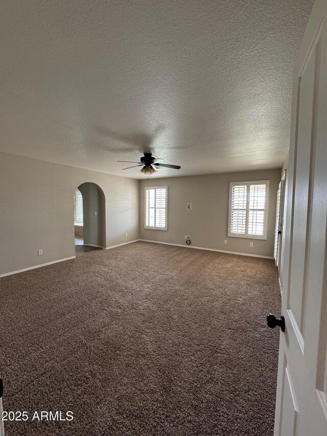 2077 N Lake Shore Dr, Casa Grande, AZ 85122 - carpeted spare room with a ceiling fan, plenty of natural light, arched walkways, and baseboards