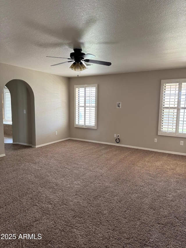 2077 N Lake Shore Dr, Casa Grande, AZ 85122 - spare room featuring a wealth of natural light, arched walkways, ceiling fan, and carpet