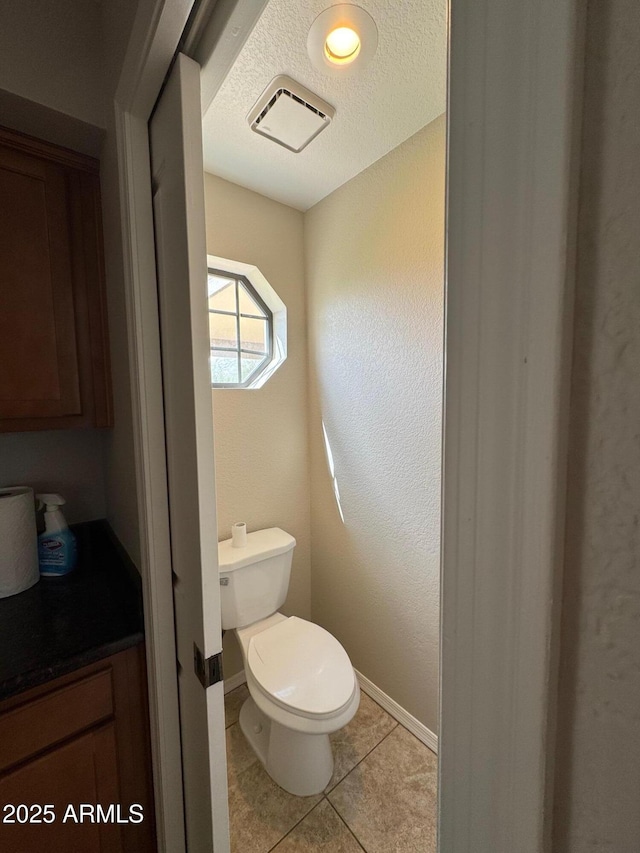 2077 N Lake Shore Dr, Casa Grande, AZ 85122 - bathroom with toilet, baseboards, a textured ceiling, tile patterned floors, and visible vents