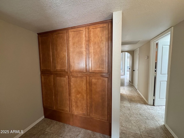2077 N Lake Shore Dr, Casa Grande, AZ 85122 - hall featuring baseboards, a textured ceiling, arched walkways, and light tile patterned floors