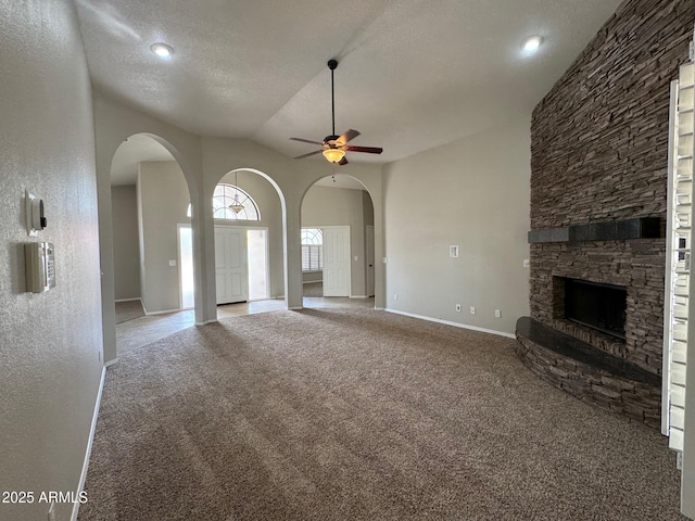 2077 N Lake Shore Dr, Casa Grande, AZ 85122 - unfurnished living room with carpet flooring, a textured ceiling, arched walkways, ceiling fan, and a fireplace