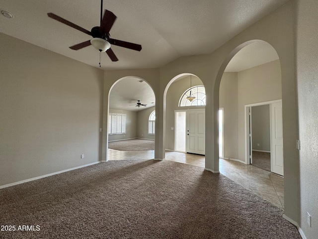 2077 N Lake Shore Dr, Casa Grande, AZ 85122 - unfurnished room featuring arched walkways, light tile patterned floors, a ceiling fan, and light colored carpet