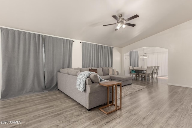 living room with lofted ceiling, hardwood / wood-style flooring, and ceiling fan