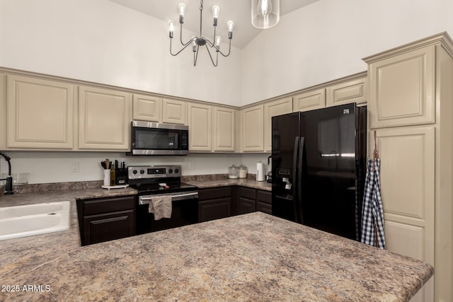 kitchen with sink, decorative light fixtures, high vaulted ceiling, appliances with stainless steel finishes, and cream cabinetry