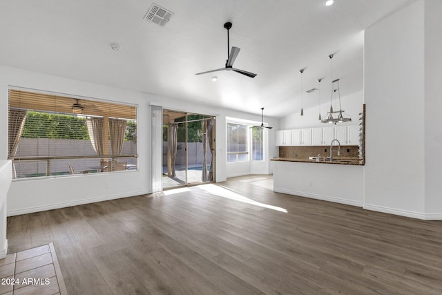 unfurnished living room featuring hardwood / wood-style flooring, ceiling fan, lofted ceiling, and sink