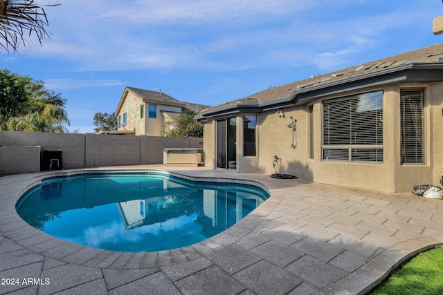 view of swimming pool with a patio and a hot tub