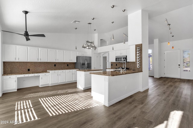 kitchen with pendant lighting, high vaulted ceiling, kitchen peninsula, white cabinetry, and stainless steel appliances