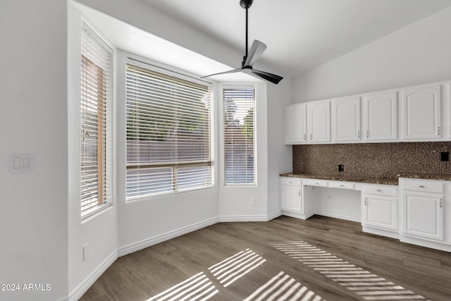 interior space featuring lofted ceiling, white cabinets, hardwood / wood-style flooring, ceiling fan, and built in desk