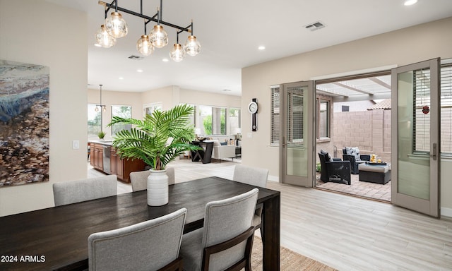 dining room featuring french doors, light hardwood / wood-style floors, and an inviting chandelier