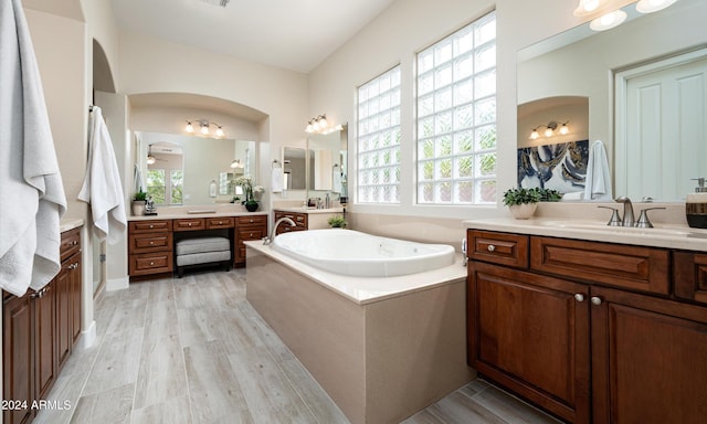 bathroom with hardwood / wood-style floors, vanity, ceiling fan, and a wealth of natural light